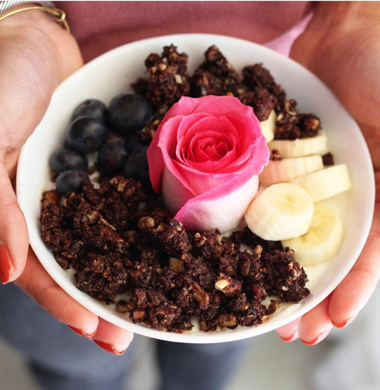 Chocolate granola in a bowl with rose in the center