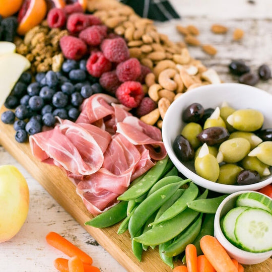 Board with olives, fruits and cold cuts